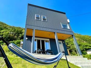 a blue house with a hammock in front of it at BEACH HOUSE Kamogawa - Vacation STAY 64005v in Kamogawa