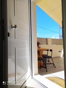 a sliding glass door leading to a balcony with a table at D&K Studio - Nafplio in Nafplio