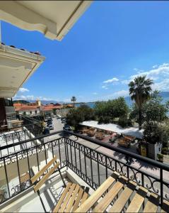 a balcony with two wooden benches and a street at Regina Hotel in Nafpaktos