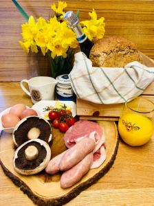 a table with eggs sausage and bread and a bottle of wine at Luxury Stargazing Glamping - Seren Aur in Llanidloes