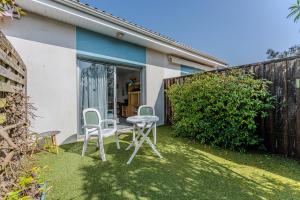 eine Terrasse mit 2 Stühlen und einem Tisch im Hof in der Unterkunft Cap Ferret Océan - Réf 184 in Lège-Cap-Ferret