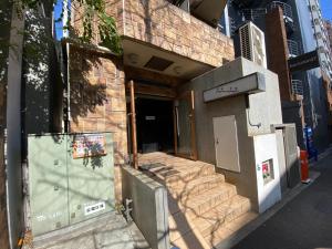 ein Gebäude mit einer Treppe, die zu einer Tür führt in der Unterkunft walk to JR Shibuya sta.-YoYY in Tokio