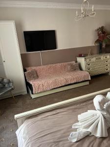 a bedroom with a bed and a tv on the wall at Pensiunea Baroc in Braşov