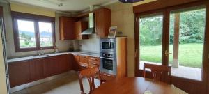 cocina con mesa de madera, mesa y sillas en Villa Urdaibai, en Busturia