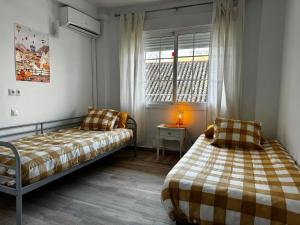 sypialnia z 2 łóżkami i oknem w obiekcie TuHome Neptuno I w mieście Fuengirola