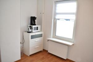 une petite cuisine avec un four micro-ondes et une fenêtre dans l'établissement Wattwurm, à Wyk auf Föhr 1 autre photo
