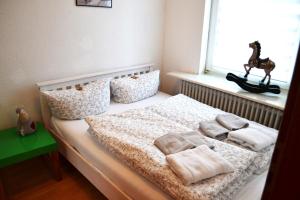 une chambre avec un lit avec des oreillers et une fenêtre dans l'établissement Wattwurm, à Wyk auf Föhr