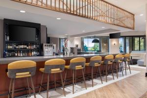 a bar with a row of stools in a room at The Westin Dallas Stonebriar Golf Resort & Spa in Frisco