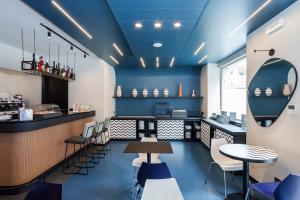 a restaurant with blue ceilings and tables and chairs at Aparthotel Colombo Roma in Rome