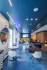 a cafeteria with tables and chairs in a room at Aparthotel Colombo Roma in Rome