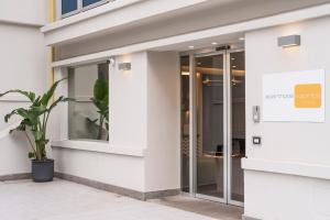 un accès à un bâtiment avec des portes en verre dans l'établissement Aparthotel Colombo Roma, à Rome