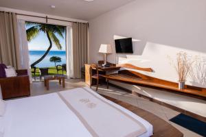 a bedroom with a bed and a view of the ocean at Mantis Soanambo Hotel And Spa in Sainte Marie