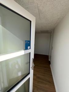 un couloir vide avec une porte et une chambre dans l'établissement Go-Sleep Bredehus, à Bredsten