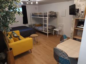 sala de estar con 2 literas y sofá en Appartement tout confort, en Le Fresne-Camilly