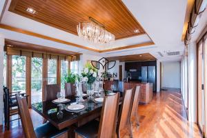comedor y cocina con mesa de comedor y sillas en Yizen Beachfront Seaview Villa, en Norte de Pattaya