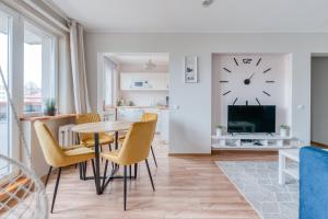 sala de estar con mesa, sillas y reloj en la pared en Kesklinna majutus en Haapsalu