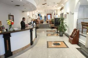 a man sitting at a counter in a salon at Gran Hotel Ailen in Buenos Aires