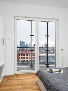 a bedroom with a large window with a view of a city at Warsaw Apartments Bliska Wola in Warsaw