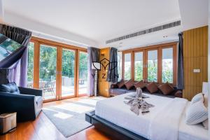 Un dormitorio con una gran cama blanca y un sofá. en Yizen Beachfront Seaview Villa, en Norte de Pattaya 116 fotos más