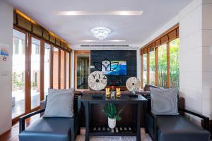 una sala de estar con una mesa y sillas en Yizen Beachfront Seaview Villa, en Norte de Pattaya