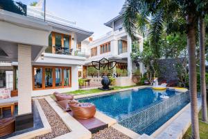 una casa con piscina delante de una casa en Yizen Beachfront Seaview Villa, en Norte de Pattaya