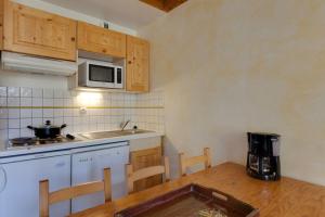 a small kitchen with a table and a microwave at Meijotel - 508 - Appart duplex - 6 pers in Les Deux Alpes