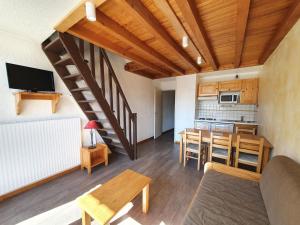 a living room with a table and a kitchen at Meijotel - 508 - Appart duplex - 6 pers in Les Deux Alpes