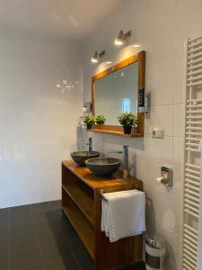 La salle de bains est pourvue de 2 lavabos et d'un miroir. dans l'établissement Hotel Courage Gulpen-Wittem, à Gulpen