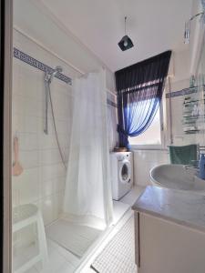 uma casa de banho com um chuveiro, um lavatório e uma máquina de lavar roupa em Felicitas (Charming House) em Lerici