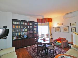 uma sala de estar com uma mesa e uma estante de livros em Felicitas (Charming House) em Lerici