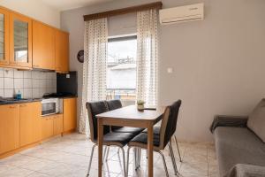 cocina y comedor con mesa y sillas en Special Apartment, en Larisa