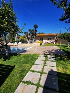 a garden with a stone path leading to a house at Villa MATA - 600m² with Private Pool and Jacuzzi in Kalithies
