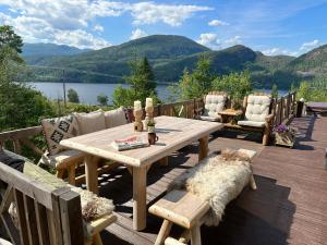 a wooden table and chairs on a deck with a view at Panorama Cabin with 5-bedrooms near Norefjell in Gubberud