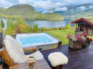 GubberudにあるPanorama Cabin with 5-bedrooms near Norefjellの湖の景色を望むデッキ(ホットタブ付)