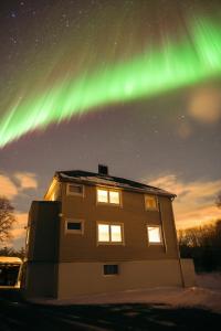 un edificio de apartamentos con la aurora en el cielo en Island Getaway: Sea and Mountain Views en Ålesund