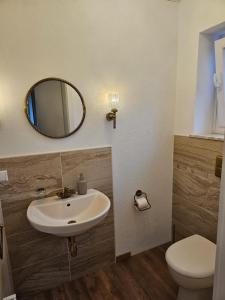 La salle de bains est pourvue d'un lavabo, de toilettes et d'un miroir. dans l'établissement Ferienwohnung Hambergen, à Hambergen