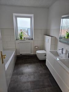 baño con aseo y lavabo y ventana en Ferienwohnung Hambergen en Hambergen