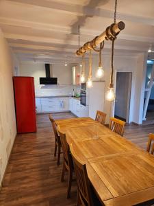 Ferienwohnung Hambergen في Hambergen: مطبخ مع طاولة وكراسي خشبية كبيرة