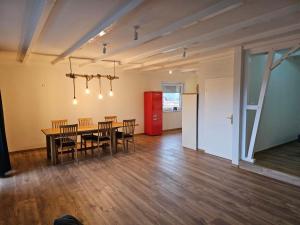 - une salle à manger avec une table, des chaises et un réfrigérateur rouge dans l'établissement Ferienwohnung Hambergen, à Hambergen