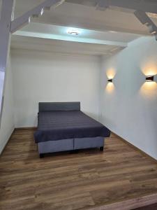 1 cama en una habitación con 2 luces en la pared en Ferienwohnung Hambergen en Hambergen