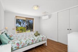 1 dormitorio con cama y ventana en Silver Sands Holiday & Beach House, en Mandurah
