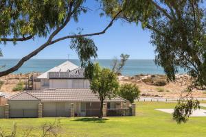 a house with the ocean in the background at Silver Sands Holiday & Beach House in Mandurah