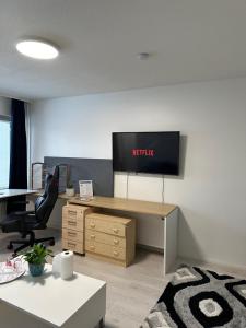 una oficina con escritorio y TV en la pared en Chic and Relaxing Studio en Hyvinkää