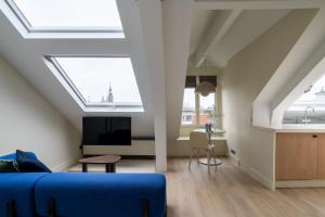uma sala de estar com tectos com clarabóia e um sofá azul em Numa Amsterdam Oosterpark em Amesterdão