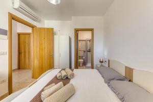 sypialnia z dużym białym łóżkiem z ręcznikami w obiekcie Camere arcobaleno fronte mare a Torre san Giovanni w mieście Torre San Giovanni Ugento