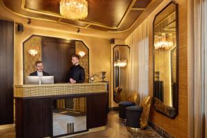 two men standing at a reception desk in a hotel lobby at Maison Cassandre in Paris