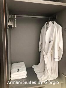 a closet with white coats and towels in it at Subang Jaya Armani Soho in Subang Jaya