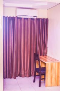 a brown curtain in a room with a wooden desk at Owee Hotel Exclusive Apartments & Suites in Lagos