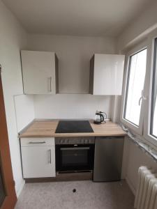 een keuken met witte kasten en een fornuis met oven bij one Room Apartment 15 min to Fair in Hannover