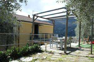 San Lorenzo della CostaにあるVilla Costa by PortofinoVacanzeのパティオ(パーゴラの下にテーブルと椅子付)